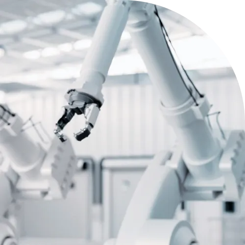 WHITE ROBOT ARMS IN A WHITE INDUSTRIAL  HALL.